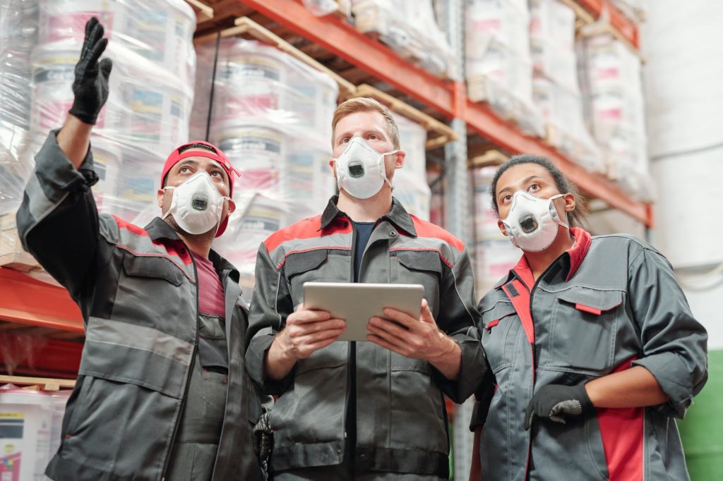Young contemporary intercultural warehouse workers having discussion at work